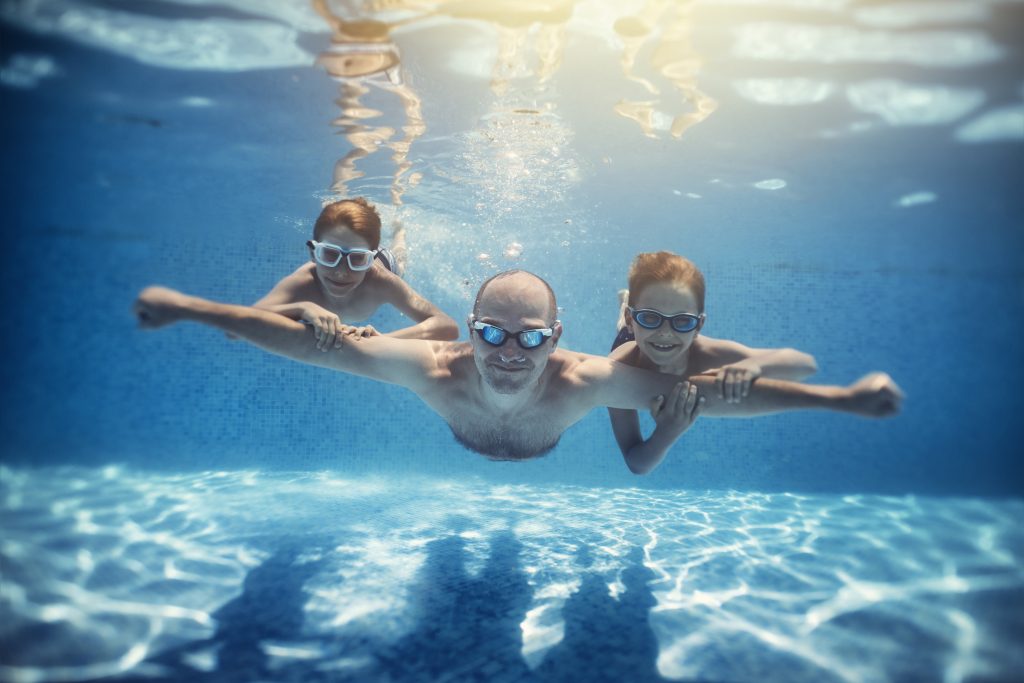 father-and-sons-playing-underwater-in-resort-pool-2